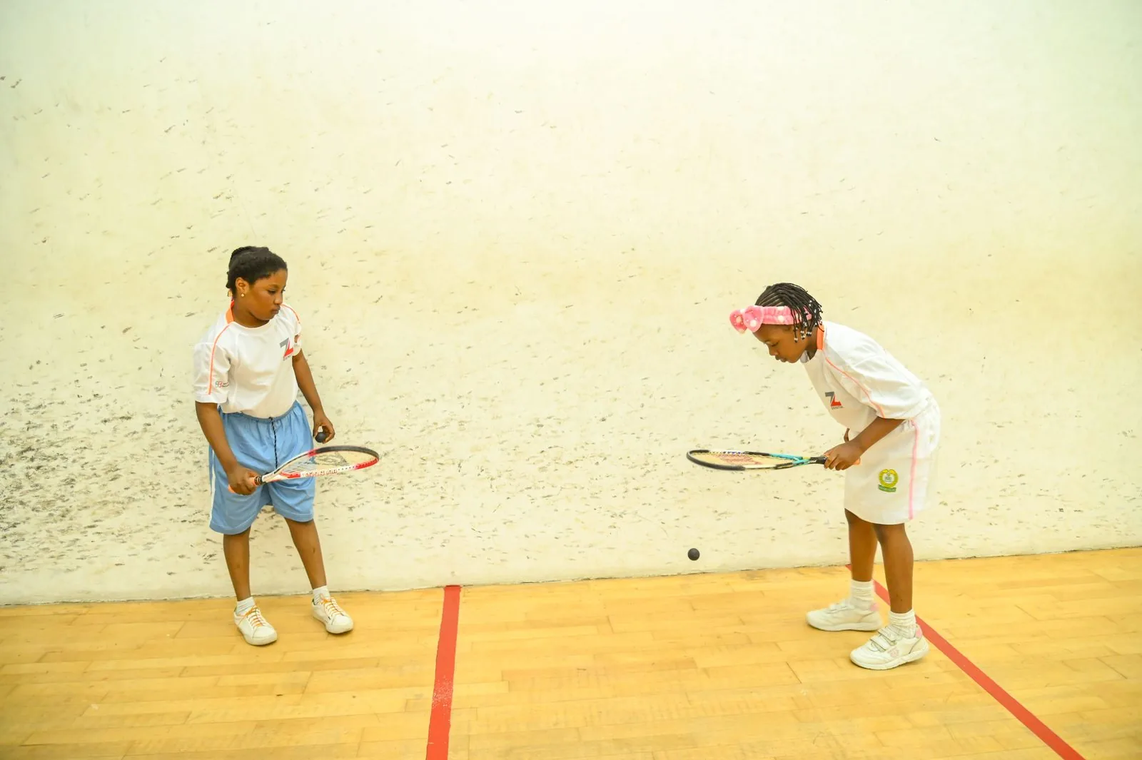 Two girls playing squash on court