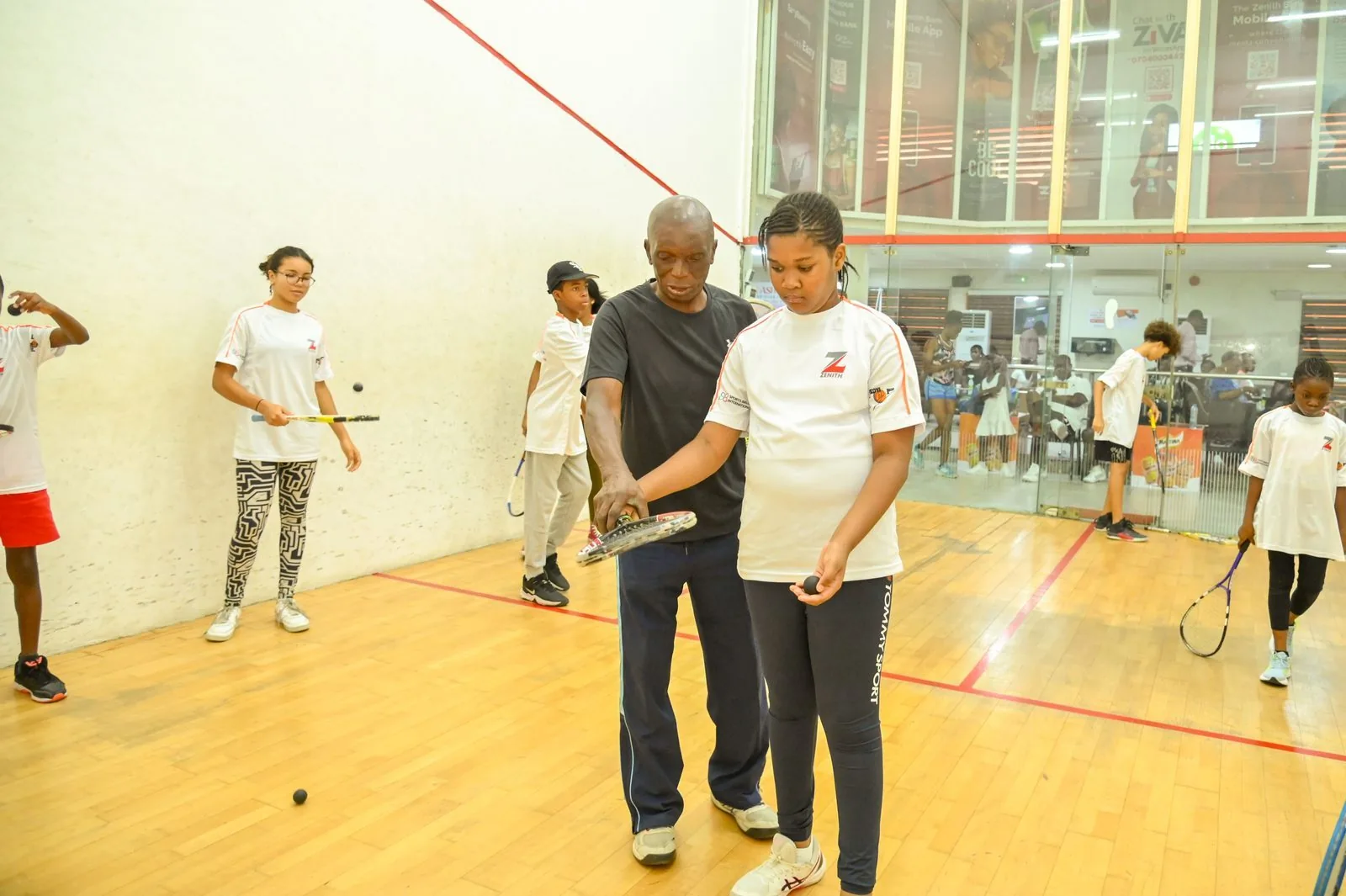 A coach working with a young girl on her grip