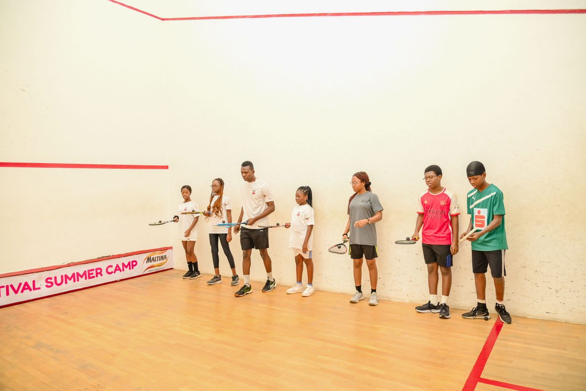 Teenagers lined up attentively with squash rackets during a structured session at the Ikoyi Club Squashtival Summer Camp