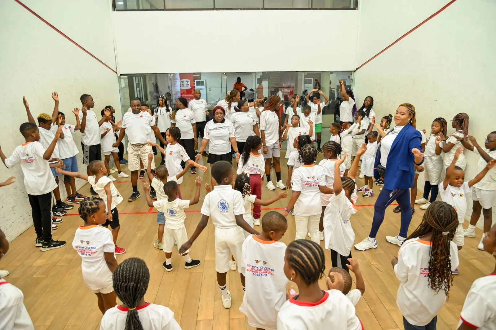A large group of children warming up together on the court